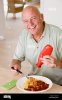 homme-mettant-ketchup-de-nourriture-kjc375.jpg
